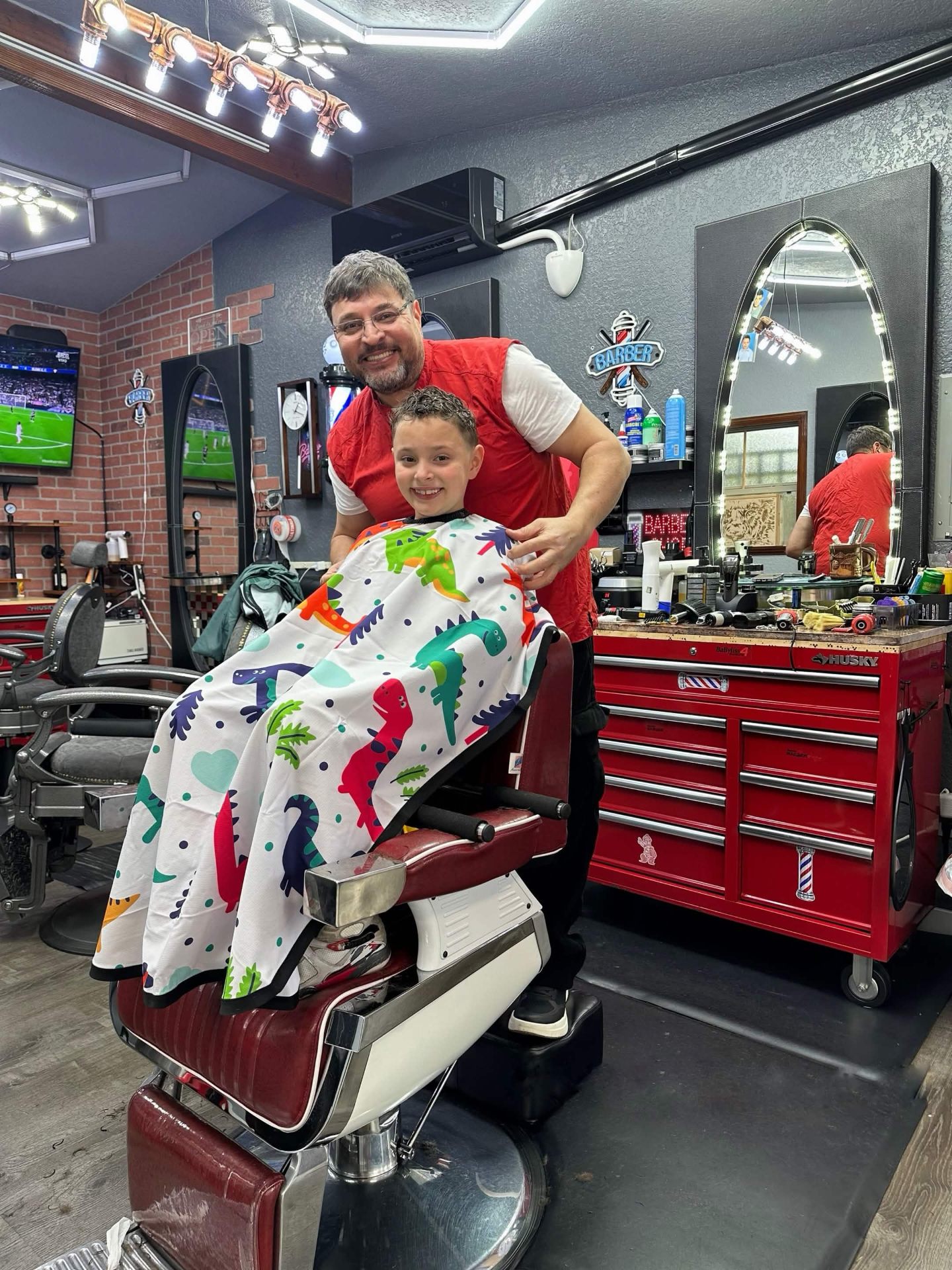 Dennis with a young client in the barber chair at Barbershop DD